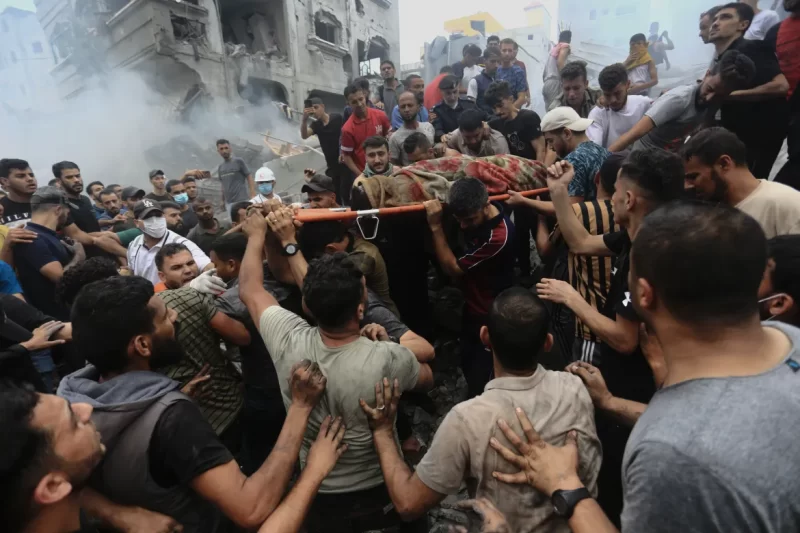 FOTO : Warga Palestina mengeluarkan jenazah dari puing-puing bangunan setelah serangan udara Israel di kamp pengungsi Jebaliya [Ramez Mahmoud/AP Photo]
